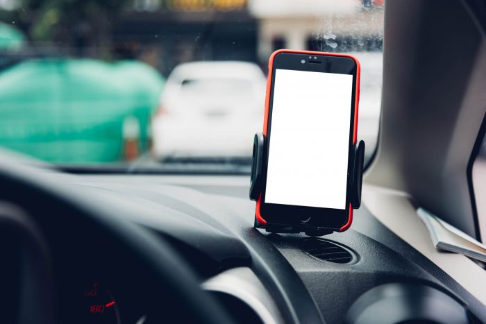 Smart phone in holder on dashboard of car