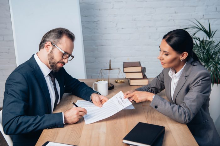 Businessman in glasses signing insurance policy contract 